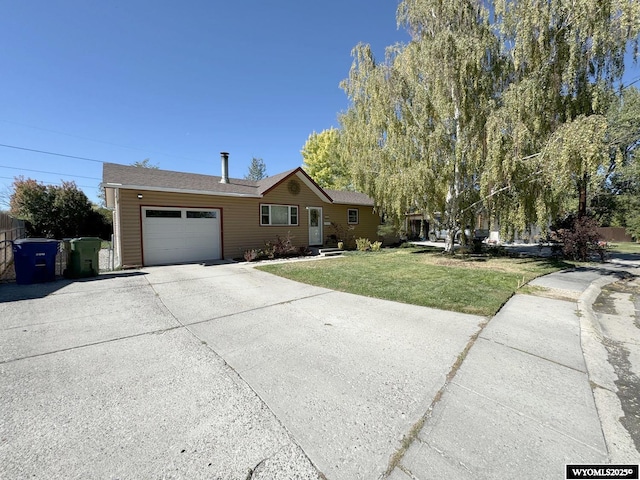 ranch-style house featuring an attached garage, concrete driveway, a front lawn, and fence