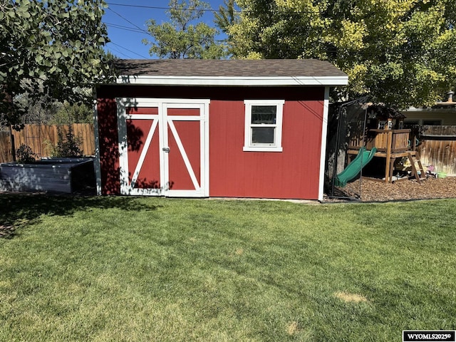 view of shed with central air condition unit, a playground, and fence