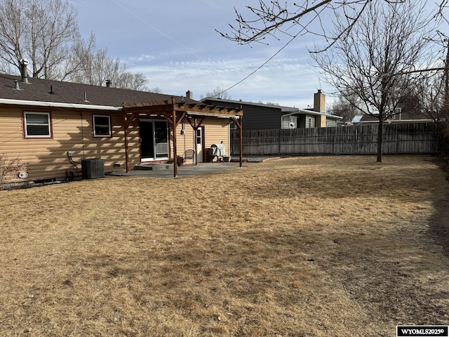 rear view of property featuring a pergola, a patio, central AC, fence, and a yard