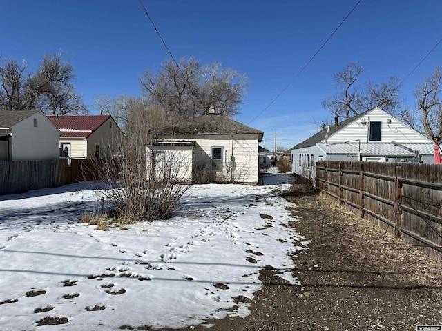 yard covered in snow featuring an outbuilding and fence