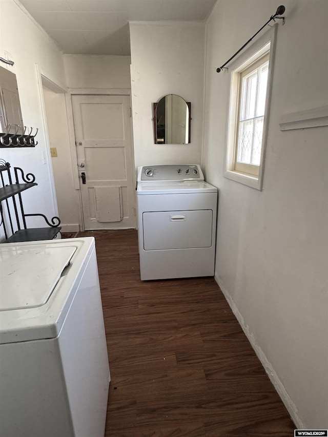 clothes washing area featuring baseboards, dark wood finished floors, laundry area, and washer and clothes dryer