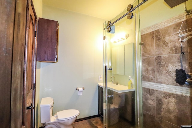 bathroom featuring baseboards, toilet, a stall shower, and vanity