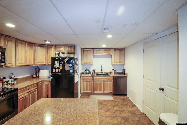 kitchen with a sink, black appliances, recessed lighting, and light countertops