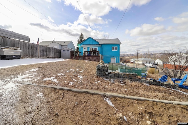 view of front of home featuring metal roof, fence, an outdoor structure, and a shed