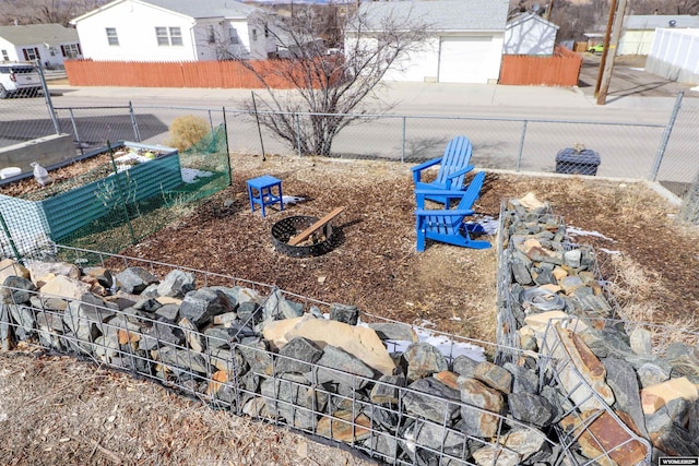 view of yard featuring a garage, a vegetable garden, and fence