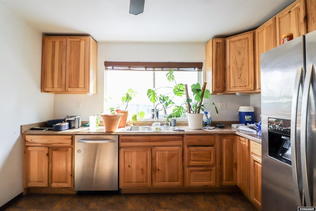 kitchen featuring light countertops, brown cabinetry, stainless steel appliances, a ceiling fan, and a sink