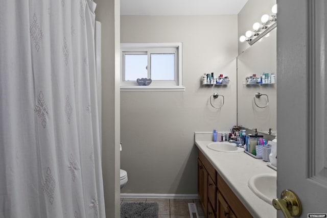 bathroom featuring tile patterned floors, visible vents, baseboards, and a sink