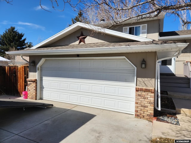 garage with driveway and fence