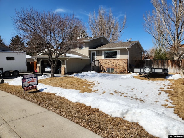 view of front of home with brick siding and fence