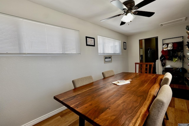 dining room with ceiling fan, visible vents, baseboards, and wood finished floors