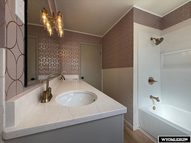 bathroom featuring wallpapered walls, bathing tub / shower combination, vanity, and ornamental molding