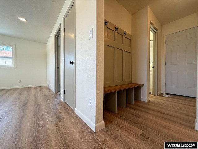 mudroom with recessed lighting, baseboards, and wood finished floors