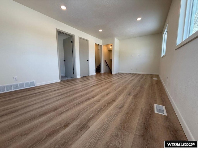 spare room with recessed lighting, wood finished floors, visible vents, and baseboards