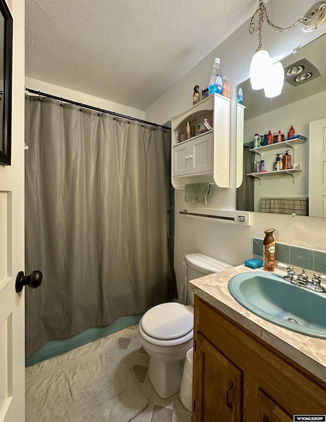 full bath featuring a shower with shower curtain, a textured ceiling, toilet, and vanity