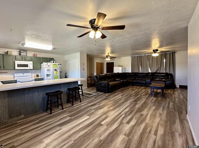 living area featuring baseboards, a textured ceiling, and wood finished floors