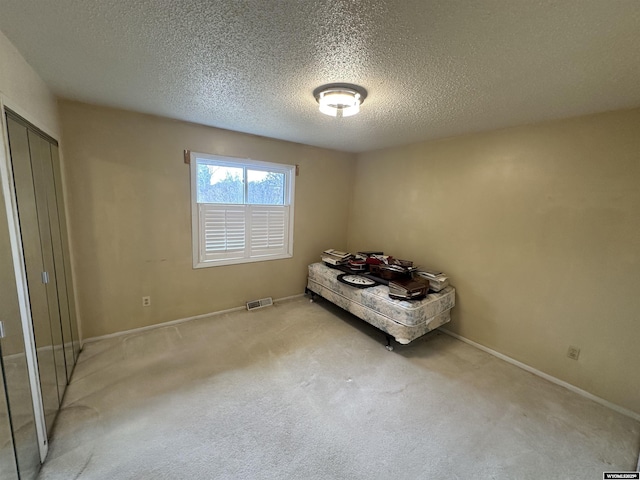 unfurnished bedroom featuring visible vents, baseboards, carpet, and a textured ceiling