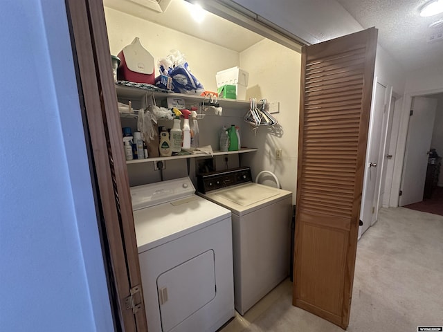 washroom with laundry area, independent washer and dryer, a textured ceiling, and light colored carpet