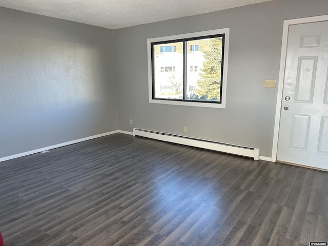 empty room with a textured ceiling, dark wood-type flooring, baseboards, and a baseboard radiator