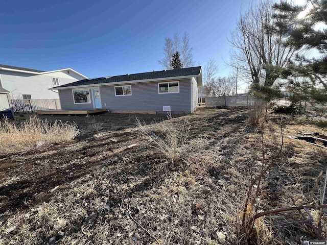 back of house with a deck and fence