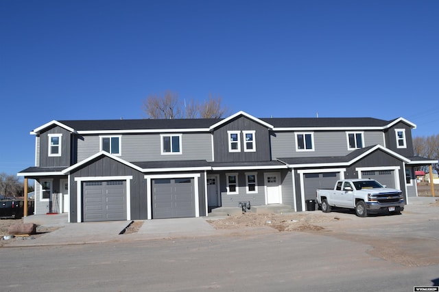 view of property featuring a porch, board and batten siding, and an attached garage