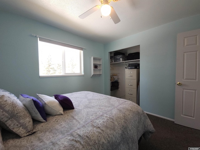 bedroom with a ceiling fan, dark colored carpet, a closet, and baseboards