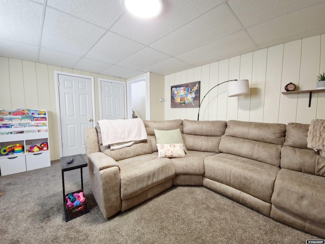 living room with a paneled ceiling and carpet floors