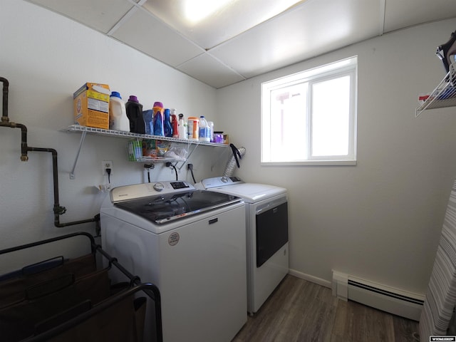 laundry area with washer and clothes dryer, a baseboard heating unit, wood finished floors, baseboards, and laundry area