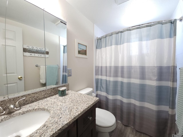 bathroom with toilet, vanity, a shower with curtain, and wood finished floors