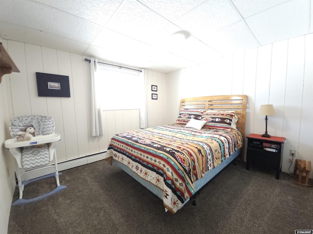 carpeted bedroom featuring a drop ceiling and a baseboard radiator