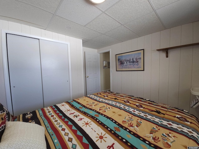 bedroom featuring a paneled ceiling and a closet