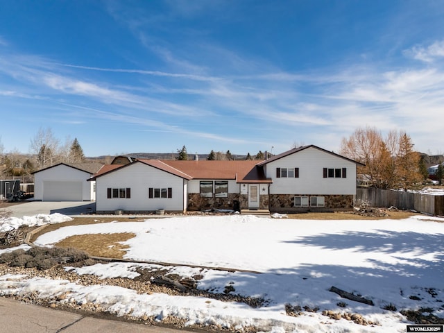 split level home with an outbuilding, a detached garage, and fence