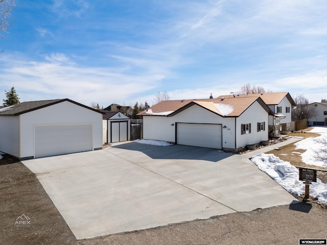 view of front of house with a garage and an outbuilding