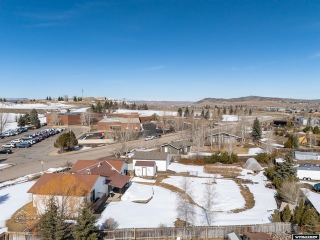 snowy aerial view featuring a mountain view and a residential view