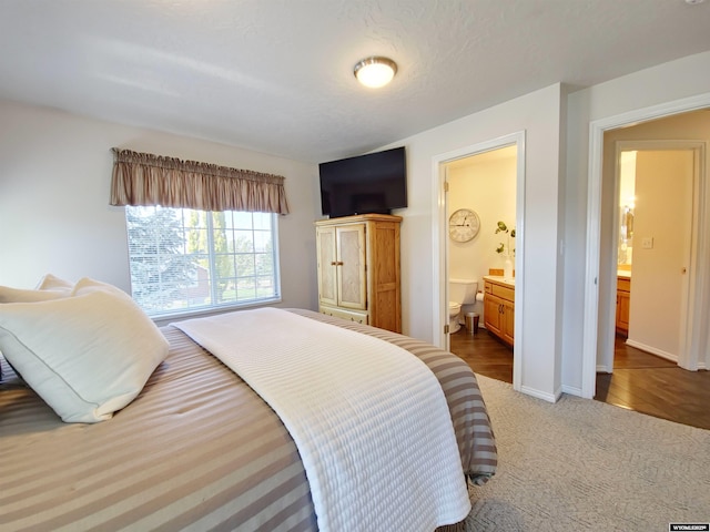 bedroom featuring connected bathroom, baseboards, and carpet flooring