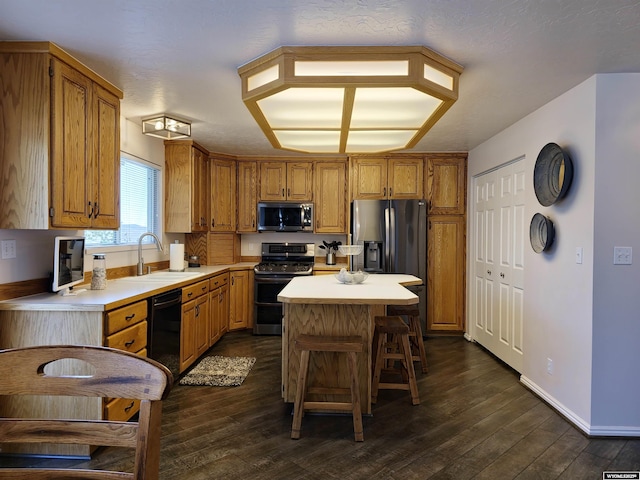 kitchen with range with two ovens, a sink, light countertops, black dishwasher, and stainless steel microwave