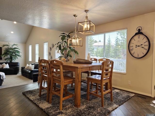 dining area with visible vents, baseboards, an inviting chandelier, lofted ceiling, and dark wood-style flooring