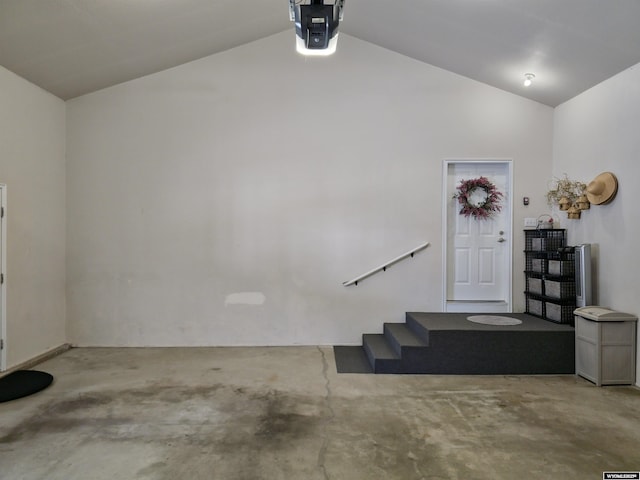 foyer featuring lofted ceiling and concrete flooring