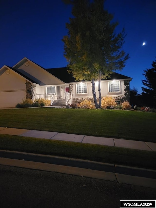 ranch-style home featuring a yard and stucco siding