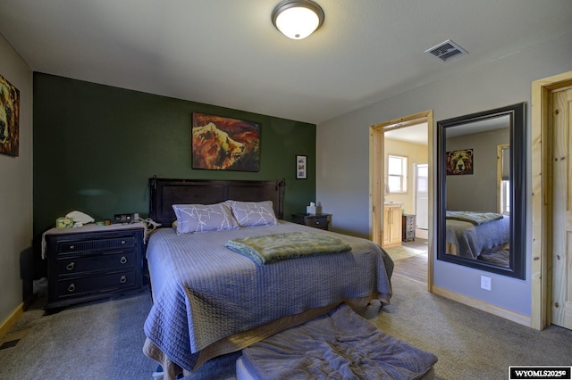 bedroom with visible vents, baseboards, carpet, and ensuite bathroom