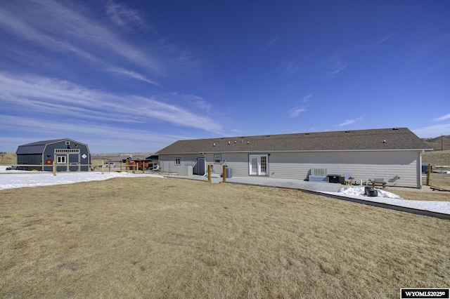 rear view of property featuring a storage unit, an outbuilding, and a patio area