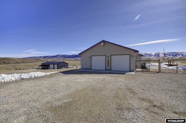 detached garage with a mountain view and fence