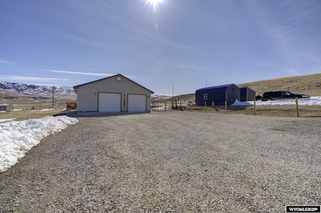 exterior space featuring a mountain view, an outdoor structure, and a garage