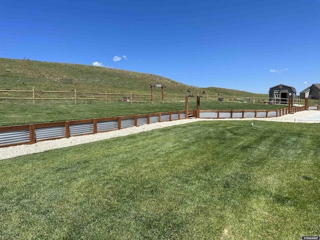 view of yard with a rural view and fence