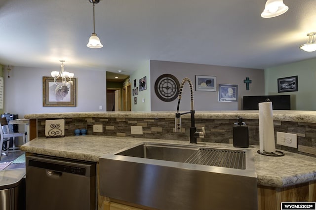 kitchen featuring tasteful backsplash, dishwasher, an inviting chandelier, hanging light fixtures, and a sink