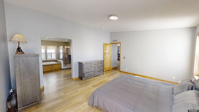 bedroom featuring vaulted ceiling, baseboards, and light wood-type flooring