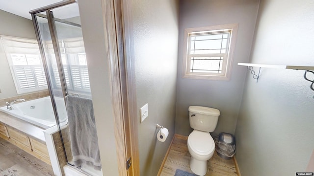 bathroom featuring a stall shower, toilet, a garden tub, and wood finished floors