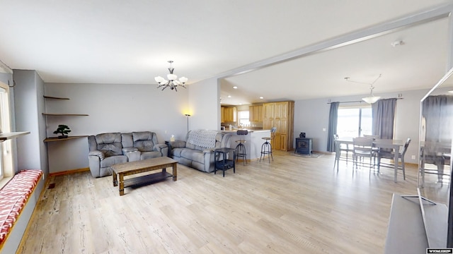 living room featuring recessed lighting, light wood-type flooring, baseboards, and a notable chandelier