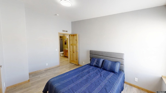 bedroom with visible vents, baseboards, and wood finished floors