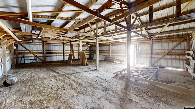 miscellaneous room featuring lofted ceiling and metal wall