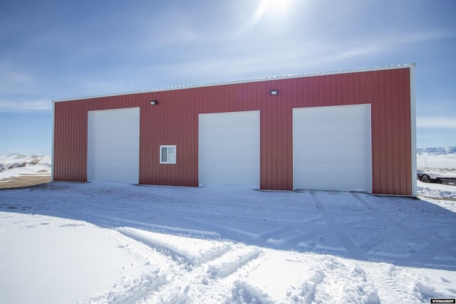 snow covered garage with a detached garage